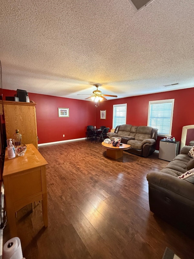 living room with ceiling fan and dark hardwood / wood-style flooring