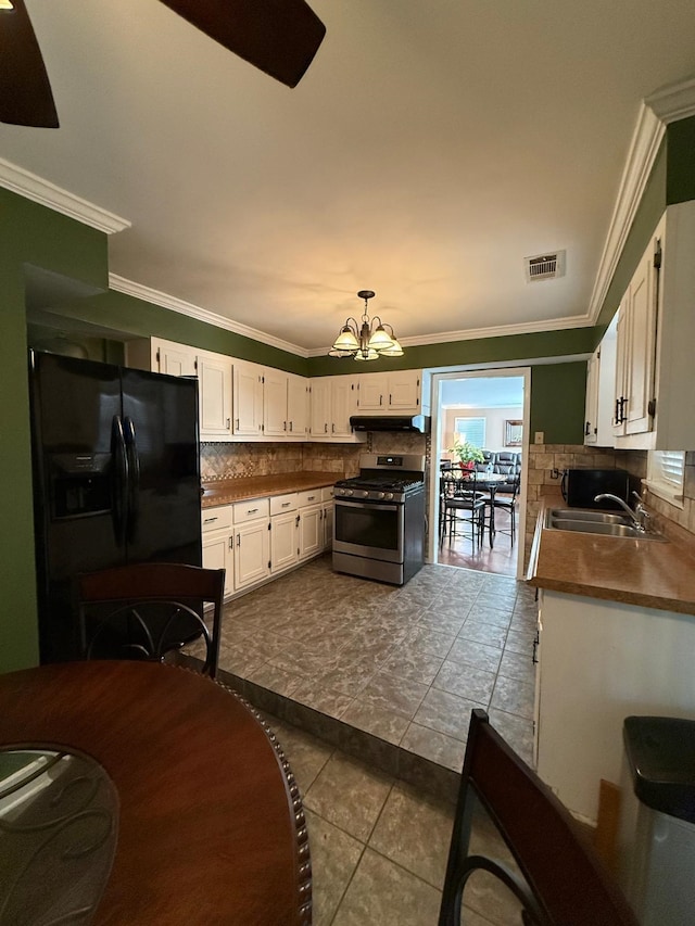 kitchen featuring white cabinets, tile patterned flooring, sink, black fridge, and stainless steel gas range oven