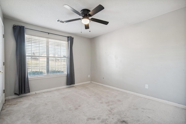 spare room with ceiling fan, light colored carpet, and a textured ceiling