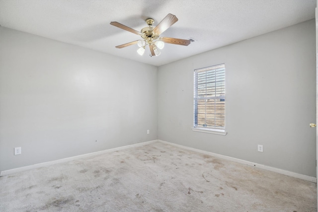 spare room featuring a textured ceiling, carpet flooring, and ceiling fan