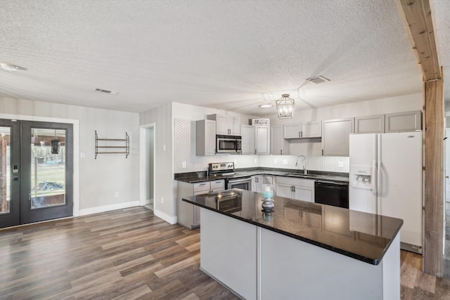 kitchen with a center island, tasteful backsplash, sink, french doors, and stainless steel appliances