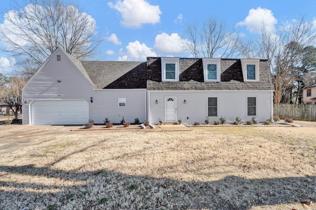 front of property with dirt driveway, a front lawn, roof with shingles, and an attached garage