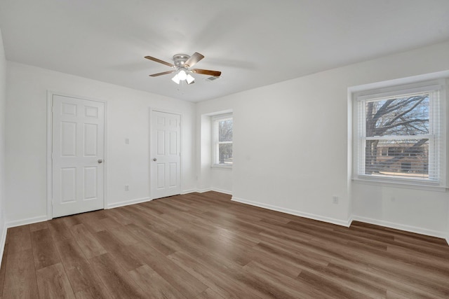 unfurnished bedroom with ceiling fan and dark hardwood / wood-style flooring