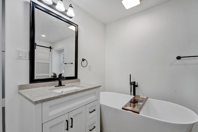 full bath with a freestanding bath and vanity