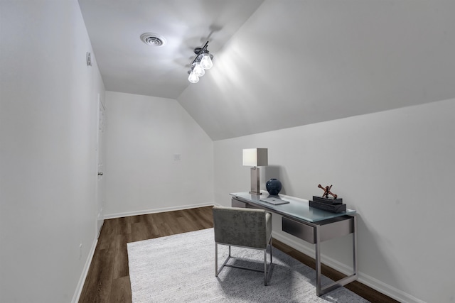 home office featuring visible vents, vaulted ceiling, baseboards, and wood finished floors