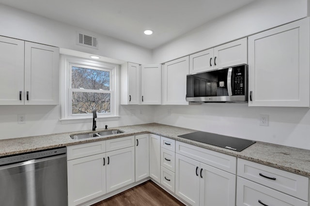 kitchen featuring dark hardwood / wood-style flooring, sink, appliances with stainless steel finishes, white cabinetry, and light stone counters