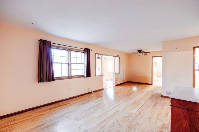 empty room featuring ceiling fan and light hardwood / wood-style flooring