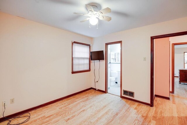 unfurnished bedroom with light wood-type flooring, ceiling fan, ensuite bathroom, and multiple windows