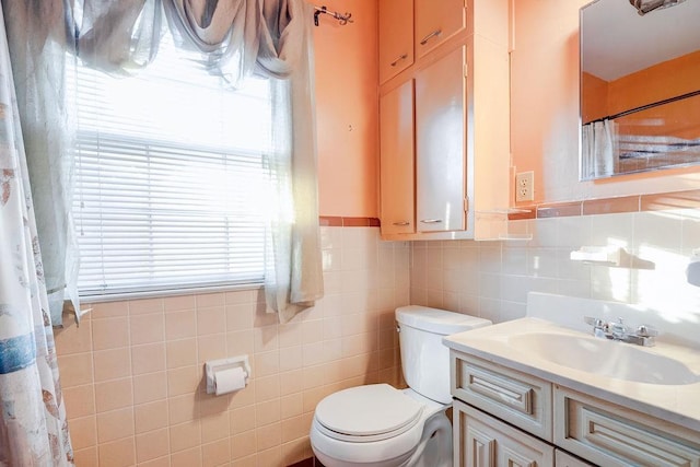 bathroom featuring tile walls, toilet, and vanity