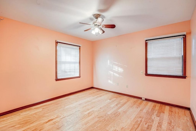 empty room with ceiling fan and light hardwood / wood-style floors