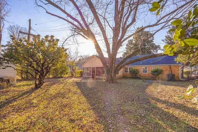 view of yard with central AC and a sunroom