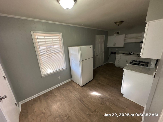 kitchen with sink, white refrigerator, white cabinets, dark hardwood / wood-style floors, and gas cooktop