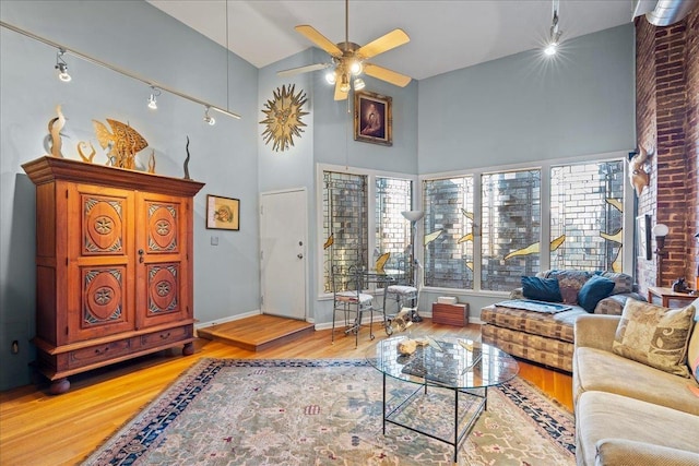 living room with hardwood / wood-style floors, a high ceiling, and ceiling fan