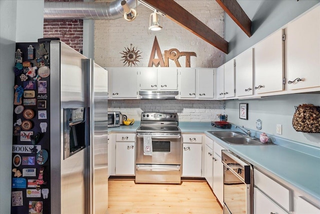 kitchen featuring appliances with stainless steel finishes, white cabinetry, brick wall, sink, and light wood-type flooring