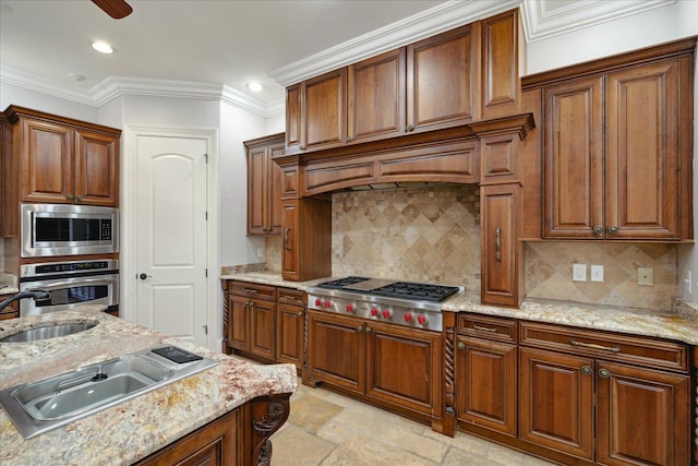 kitchen featuring light stone countertops, appliances with stainless steel finishes, sink, backsplash, and ornamental molding