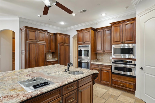 kitchen featuring decorative backsplash, sink, appliances with stainless steel finishes, and light stone countertops