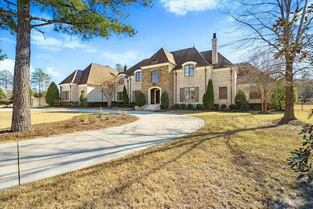 french country inspired facade with a front yard