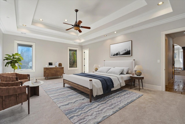 carpeted bedroom featuring ornamental molding, ceiling fan, and a raised ceiling