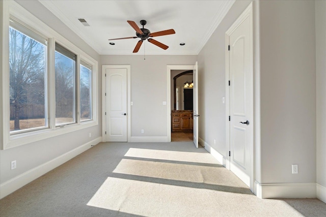 unfurnished bedroom featuring ceiling fan, ornamental molding, and light carpet