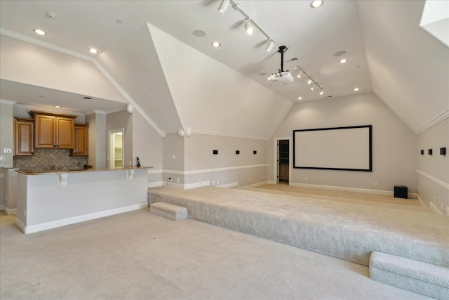 carpeted cinema room with lofted ceiling and crown molding