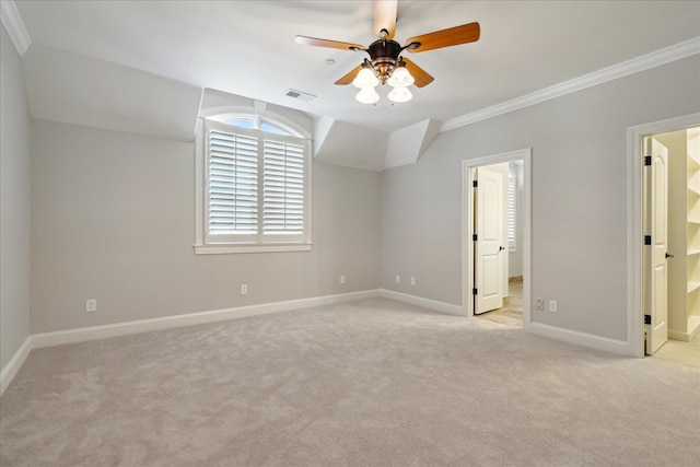 unfurnished bedroom featuring ceiling fan, light carpet, ornamental molding, and ensuite bath