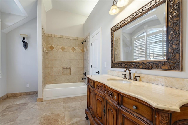 bathroom with tiled shower / bath combo and vanity