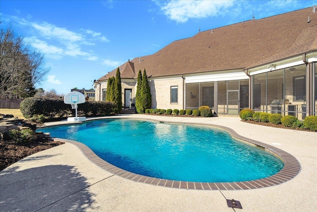 view of pool featuring a sunroom and a patio area