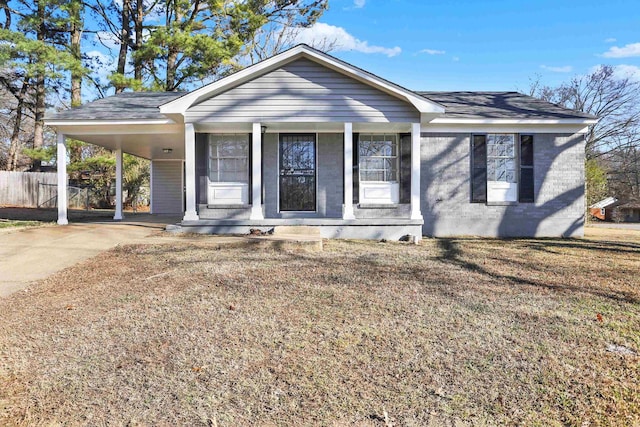 ranch-style house with covered porch, a carport, and a front lawn