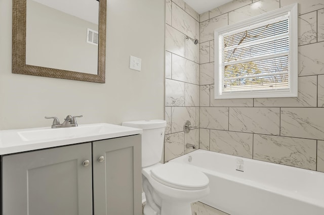 full bathroom featuring tiled shower / bath combo, toilet, and vanity