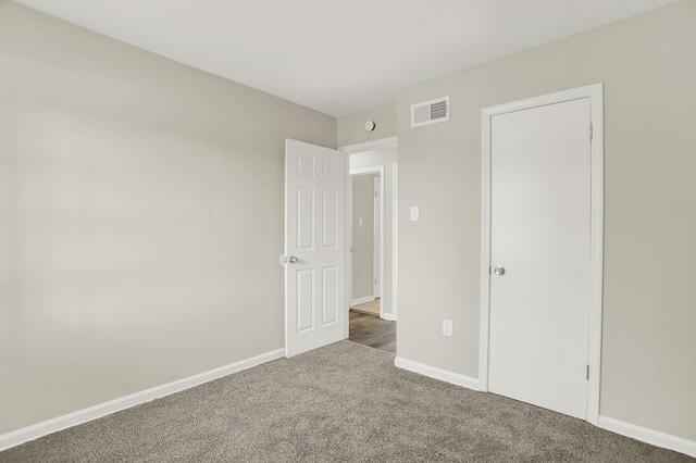 unfurnished bedroom with dark colored carpet