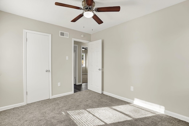 unfurnished bedroom featuring dark carpet and ceiling fan