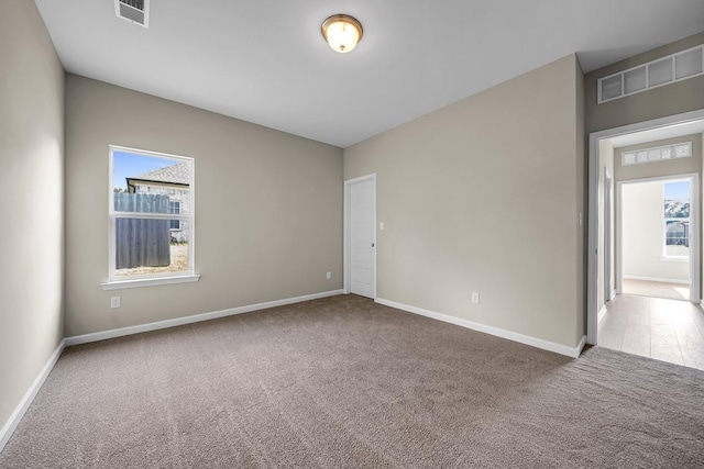 unfurnished room with light colored carpet and a healthy amount of sunlight