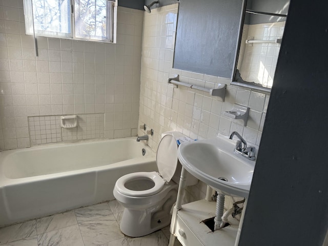 full bathroom featuring tile walls, sink, tiled shower / bath combo, toilet, and decorative backsplash