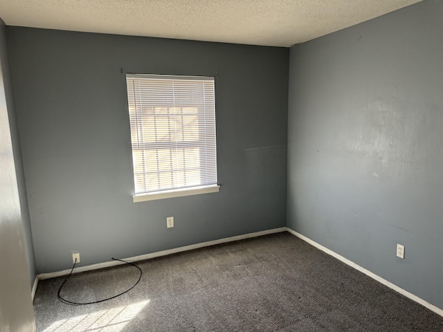 carpeted empty room with a textured ceiling