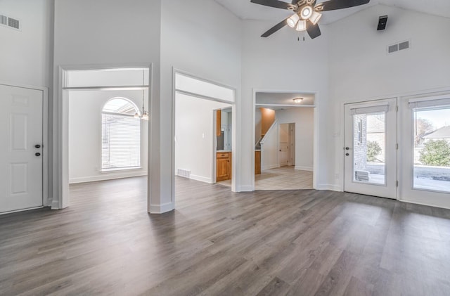 foyer entrance with high vaulted ceiling, a wealth of natural light, hardwood / wood-style flooring, and ceiling fan