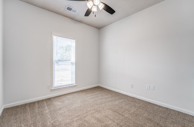 carpeted empty room featuring ceiling fan and a wealth of natural light