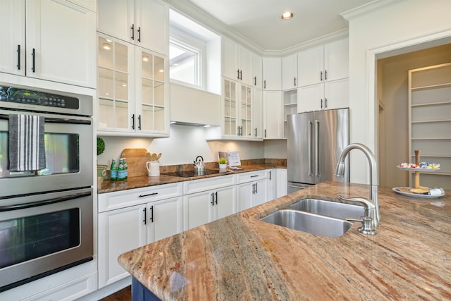 kitchen featuring light stone counters, white cabinetry, and stainless steel appliances