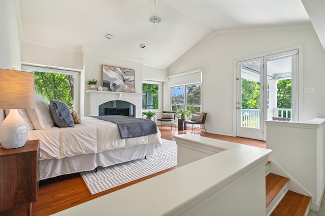 bedroom with wood-type flooring, access to outside, and vaulted ceiling