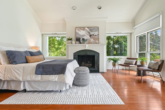 bedroom featuring hardwood / wood-style flooring, multiple windows, and ornamental molding