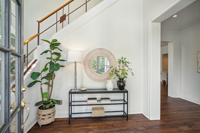 foyer entrance with dark wood-type flooring and ornamental molding