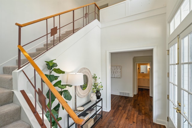 staircase with hardwood / wood-style floors and french doors