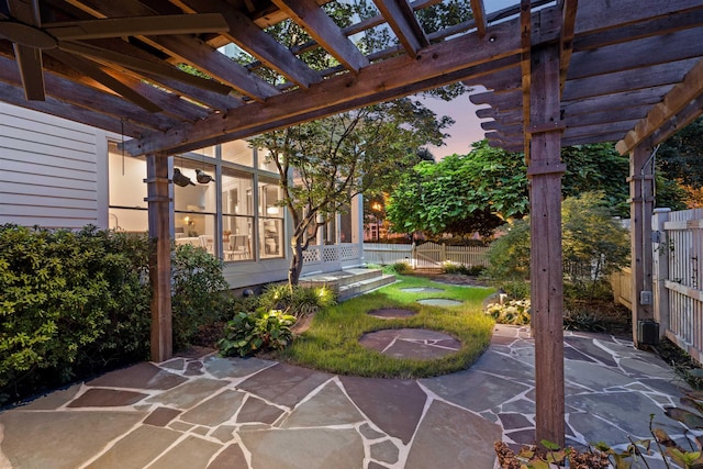 patio terrace at dusk featuring a yard and a pergola