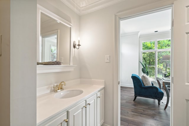 bathroom with wood-type flooring, vanity, and crown molding