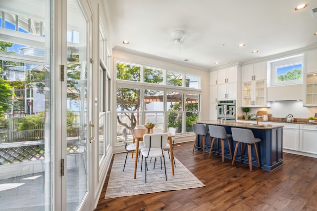 dining space featuring ornamental molding and dark hardwood / wood-style flooring