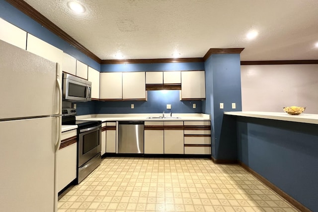 kitchen with stainless steel appliances, sink, a textured ceiling, and white cabinets