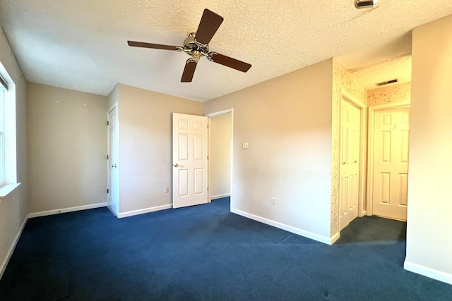 unfurnished bedroom featuring dark carpet, a textured ceiling, ceiling fan, and a closet