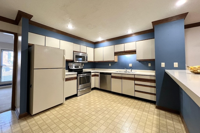 kitchen with sink, ornamental molding, a textured ceiling, and appliances with stainless steel finishes