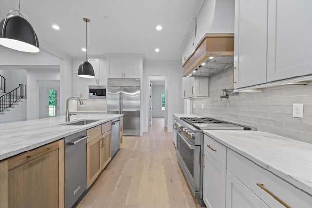 9170 Old Green Ln, Germantown, TN 38138 - kitchen with high end appliances, custom range hood, decorative backsplash, light wood-style flooring, and light stone counters