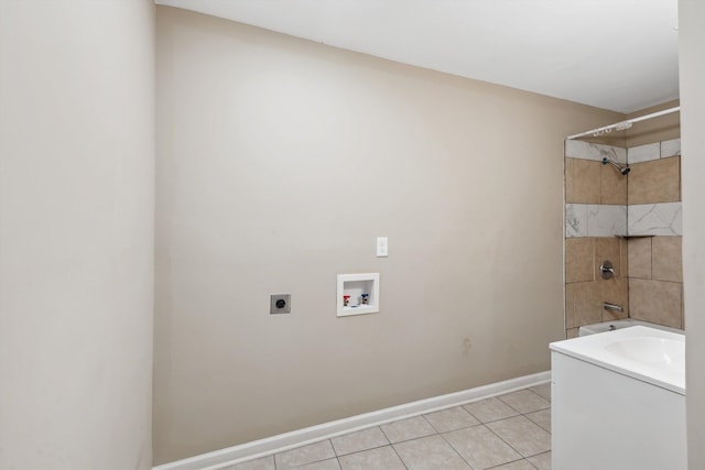 clothes washing area with hookup for an electric dryer, washer hookup, and light tile patterned floors