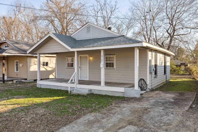 bungalow-style home with covered porch and a front lawn